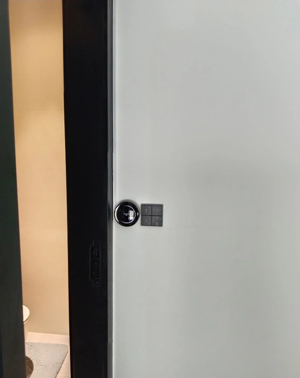 Round wall control and touch panel beside an interior doorway in a Dubai villa