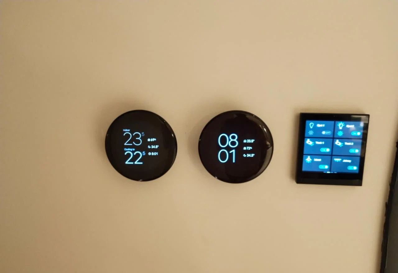 Two round room thermostats and a wall-mounted touch panel in a Dubai villa