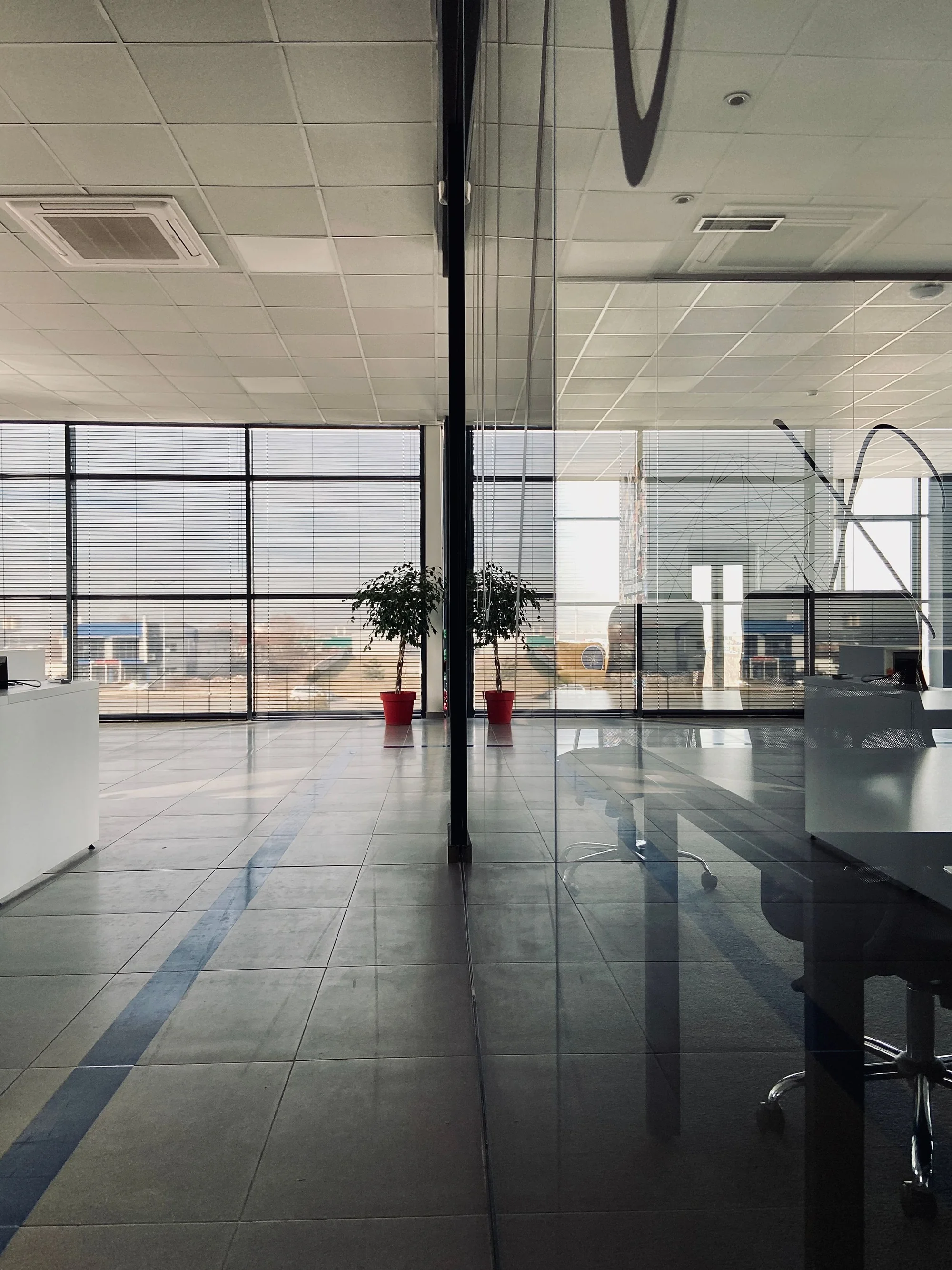 Representative office interior with glass partitions and reflective surfaces